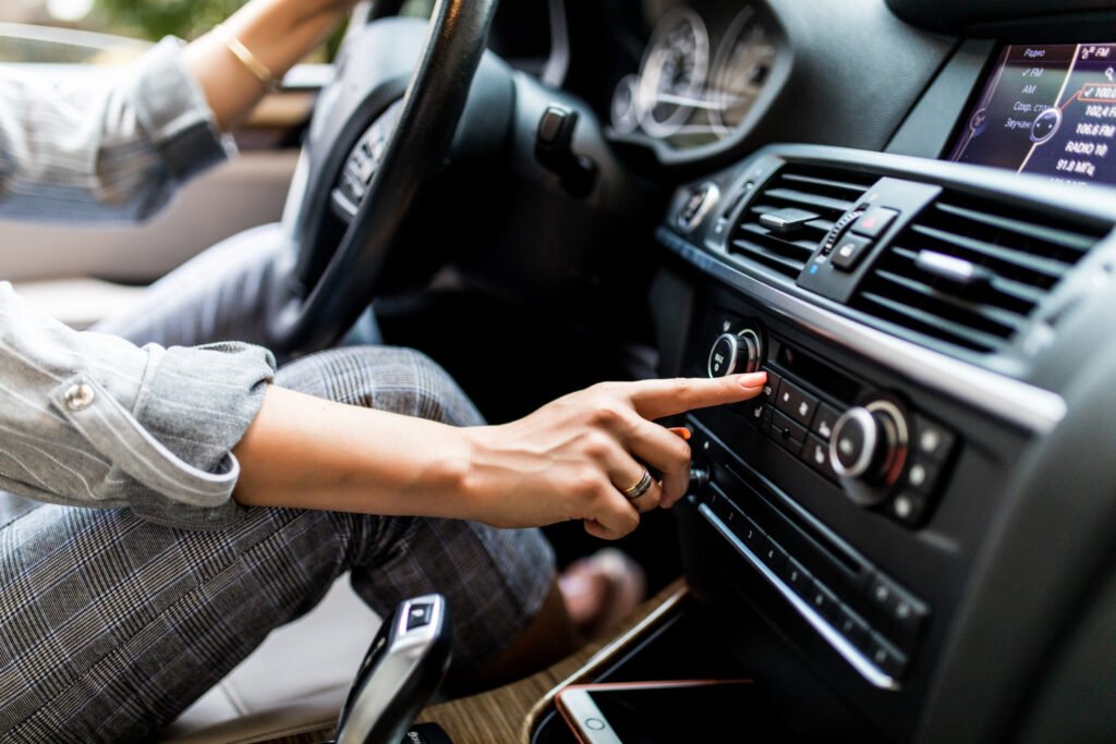 car-dashboard-radio-closeup-woman-sets-up-radio-while-driving-car